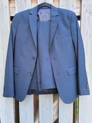 Mörkblå klassisk kostymkavaj - Kavaj och kostymbyxor från Cubus stl 164. (Passar i längd uppemot 170 cm). I nyskick. Använda en gång. Nypris 1100kr. Nu 600kr. Perfekt till sommarens skolavslutningar och andra festligheter.