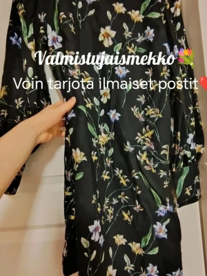 Svart blommig klänning med knappar❤️ 2000s H&M.  - Snygg svart klänning med färgglatt blommönster och långa ärmar💐 Klänningen har dekorativa knappar längs ärmsluten och en rak, något lös passform. Perfekt för dig som gillar en romantisk och trendig stil❤️ 