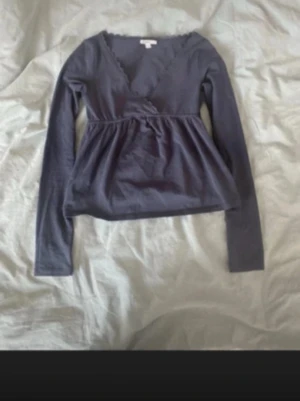 Mörkblå omlottopp från subdued - Supersöt mörkblå omlottopp från subdued med v-ringning och spetsdetaljer längs halsen. Långärmad och i mjuk bomull, perfekt för att skapa en chill och snygg look. Passformen är normal och toppen har en lätt rynkad effekt under bysten.