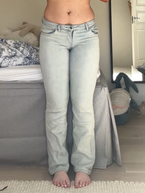 HM jeans - Säljer ett par ljusblå bootcut jeans med klassisk femficksdesign och snygga ficklock bak. Knapparna på bakfickorna har tyvärr trillat av men det syns ej. Jeansen har låg midja och är tillverkade i ett mjukt denimtyg med lite stretch för skön passform. Perfekta till en avslappnad och trendig look.