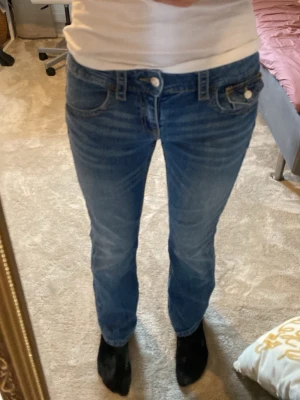 Blå bootcut jeans med låg midja från Gina Tricot - Snygga blå bootcut jeans med låg midja och klassiska fem fickor. Jeansen har en lätt tvättad look och utsvängda ben. Perfekta för en avslappnad och trendig stil.