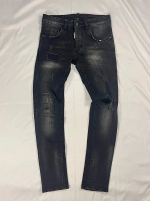 DSQUARED2 Skinny Dan Jean J032 - DSQUARED2 Skinny Dan färg: Mörkgrå/black washed | Modell: Skinny Dan Jean J032 | Storlek: W42 | Skick: 10/10 | Stretch | Distressed/patch detaljer | Hör av dig vid frågor!