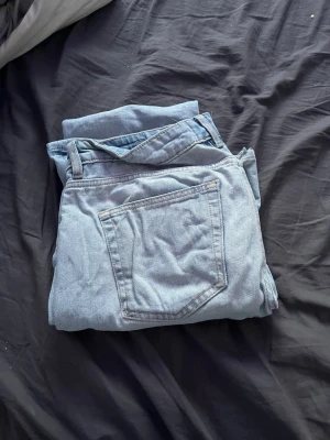 Ljusblå jeans från 157 - Säljer ett par ljusblå jeans från 157 med klassisk femficksdesign och raka ben. Jeansen är tillverkade i denim och har en snygg, avslappnad passform. Perfekta för dig som gillar en enkel och stilren look.