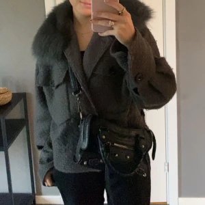 Meotine jacka - Säljer en grå meotine jacka med stor fluffig pälskrage. Jackan har oversized passform, stora fickor framtill och knappar. Perfekt för dig som vill ha en mysig och trendig look under höst och vinter. Den är i s/m och sitter lagom oversized på mig som är xs/ och 161 lång.💕 Kan gå ner i pris!!💕