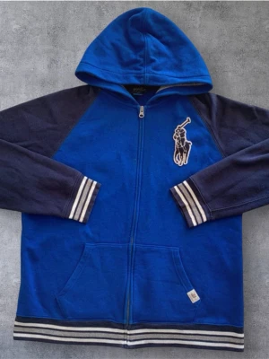 Unik Ralph Lauren zip hoodie - Säljer en riktigt snygg och stilren Ralph Lauren zip med feta detaljer, storlek XL i barnstorlek vilket motsvarar S - M. Liten fläck ( bild 4 ) inget som syns vid användning. Pris kan diskuteras vid snabb affär😊