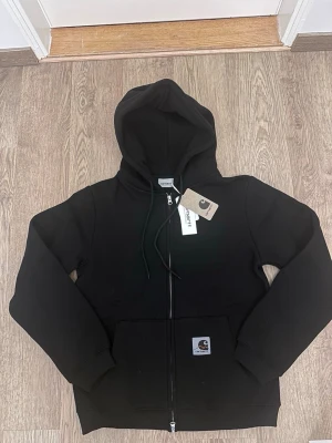 Carhart hoodie Ny - • Brand: Carhartt • Model: Hoodie • Size: M • Color: Black • Condition: New with tags Classic heavy-duty fabric with relaxed fit and iconic Carhartt logo. Perfect for everyday wear or outdoor use.