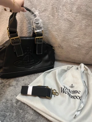 Vivienne Westwood Handväska - Svart - Tjena! Säljer nu denna efterfrågade väskan ifrån Vivienne Westwood. Skicket är 10/10. Helt ny. Medföljer dustbag extra band osv. Allt på bilderna. Vid frågor kontakta gärna!