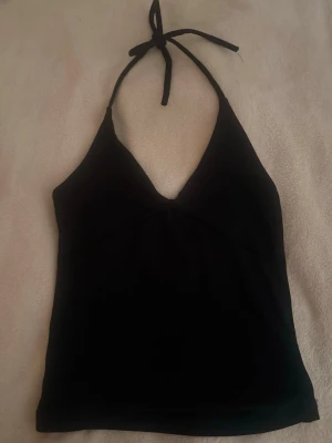 Svart necktop🦋 - Snygg svart linnetopp med halterneck och knyt i nacken. Toppen har djup v-ringning och är ärmlös, perfekt för en trendig och enkel look. Passar till många olika stilar och är lätt att matcha.