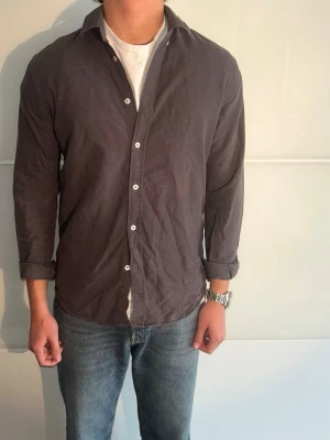 SAMSOE SAMSOE Skjorta - Säljer nu denna snygga och clean gråa skjortan från samsoesamsoe! Använd några gånger därav priset men inga defekter överhuvud taget! Modellen på bilden är 1,84 och väger 75kg! Hör av dig vid vidare fundering🤝🤝