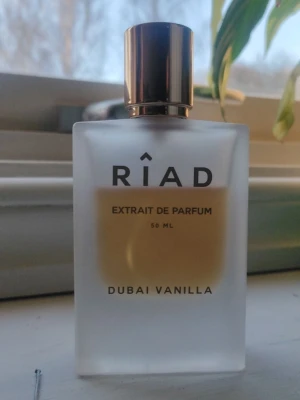 Riad Dubai Vanilla Extrait de Parfum - Riad Dubai Vanilla Extrait de Parfum är en lyxig parfym i en frostad glasflaska med guldfärgad kork. Doften är vaniljbaserad och flaskan rymmer 50 ml. Perfekt för dig som gillar söta och varma dofter med exklusiv känsla.