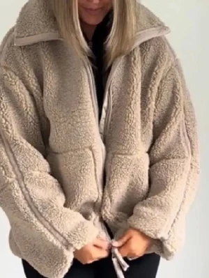 Teddy jacka  - Skriv för fler bilder eller frågor. Mysig beige teddyjacka med dragkedja framtill och hög krage. Jackan har en oversized passform, två sidofickor och justerbar dragsko nedtill. Tillverkad i fluffigt teddy-material som ger en trendig och avslappnad look. 