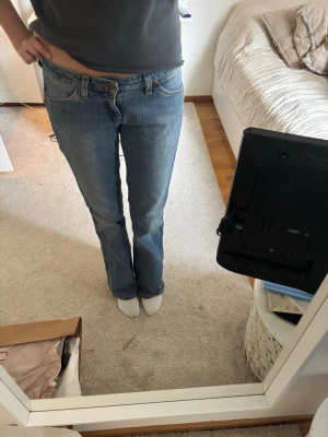 Blå raka jeans med låg midja - Säljer ett par blåa jeans. Dom har nästan inga defekter men märket är nästan lite borta på bakfickan. Men dom passar mig perfekt och jag är 175 lång och har långa ben 