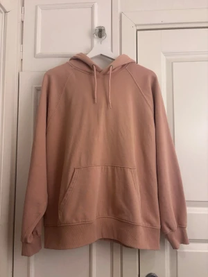 Beige oversized hoodie med ficka - Säljer en beige oversized hoodie med huva. Hoodien har en stor magficka och ribbade muddar vid ärmslut och nederkant. Perfekt för en chill och avslappnad stil. Materialet känns mjukt och skönt, troligen bomull eller bomullsblandning.