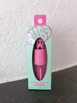 BUBS x HM Beauty Watermelon Lip Oil rosa, 3,3 ml, ny, oöppnad - Läppolja med vattenmelondoft/smak från H&M Beauty i samarbete med godisföretaget BUBS. Produkten är helt ny och såldes i limiterad upplaga.   3,3 ml Doft/smak: Watermelon