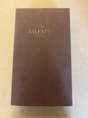 Valentino Open - Säljer ett par exklusiva sneakers från Valentino Garavani. Skorna levereras i originalkartong och med två vita tygpåsar med logga. Perfekta för dig som vill ha något lyxigt och stilrent från ett välkänt designerbrand. Säljer på grund av att dem var för små för mig, köpte för 3000. Bra skick men inte helt nya. (Pris går att diskutera)
