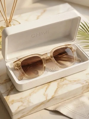 Beige solglasögon från CHIMI - Snygga solglasögon från CHIMI med transparent beige båge och bruna tonade glas. Rektangulär form som ger en modern och stilren look. Kommer i originalfodral. Perfekta för att lyfta din outfit med en trendig touch. Chimi 04