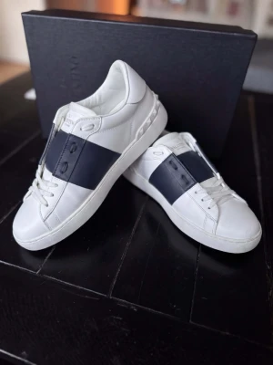  Valentino Garavani Open Sneakers – Svart | Strl 43 | Mycket Gott Skick - Valentino Garavani Open sneakers i klassisk svart — ikonisk italiensk lyx med signatur Rockstud detaljer och premium läder. Ägaren köpte in dessa via Mr Porter. Mycket gott skick med minimalt slitage. ✅ Originallåda ✅ Äktighetscertifikat ✅ Dustbag ✅ Valentino brev Storlek 43. Vi tar även emot byten och uppgraderingar. Vi reparerar, renoverar & rengör även skor — skriv i DM! 👟 📦 Spårad frakt, väl förpackad.