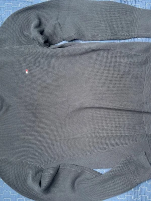 Mörkblå stickad tröja Tommy Hilfiger - Mörkblå stickad tröja från Tommy Hilfiger med diskret logga på bröstet. Tröjan har rund halsringning, långa ärmar och ribbstickade muddar. Perfekt för lager-på-lager och enkel att matcha med jeans.