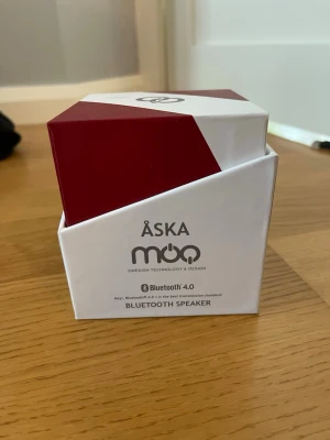 Åska Moo Bluetooth-högtalare röd - Snygg och kompakt trådlös Bluetooth 4.0-högtalare från Moo i röd och vit färg. Modern, geometrisk design med svensk teknologi och design. Perfekt för att streama musik trådlöst från mobilen eller datorn.
