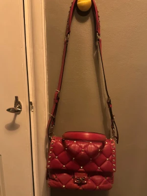 Valentino Candystud väska - Säljer nu min coola Valentino Candystud väska ❤️ Den röda färgen är ovanlig och gör verkligen väskan till en riktig statement piece. Väskan är väll använd och har sina slitningar ( se bild ) men är fortfarande väldigt fin. Vid köp tillkommer extra nitar, låda, dustbag & äkthetsbevis. Pris går att diskutera vid snabb affär
