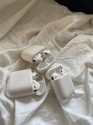 Trådlösa vita in-ear hörlurar Air pods - Säljer flera par trådlösa vita in-ear hörlurar med laddningsetui. Snygg och stilren design i plast, perfekt för musik, poddar och samtal. Smidig laddning direkt i fodralet och enkel att ta med sig överallt.