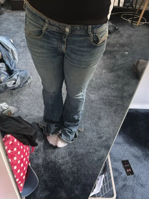 Blå bootcut jeans med låg midja - Säljer ett par blå bootcut diesel jeans med låg midja och slitningar. 
