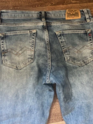 Ljusblå jeans från Replay - Snygga ljusblå jeans från Replay med klassisk femficksdesign och raka ben. Jeansen har slitna detaljer och kontrastsömmar på bakfickorna. Tillverkade i denim med en tvättad look som ger en avslappnad stil.
