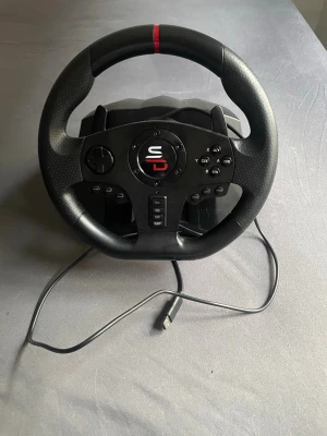 Svart Gaming ratt och pedalset - Säljer ett svart gaming ratt- och pedalset från Subsonic. Ratten har flera knappar, styrkors och USB-anslutning. Pedalerna är också svarta och har halkskydd. Perfekt för racing- och bilspel på konsol eller PC.