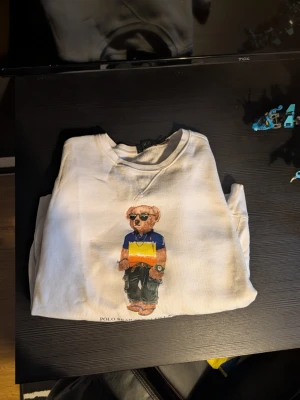 Vit sweatshirt Polo Bear från Ralph Lauren - Vit sweatshirt från Polo Ralph bear, lite märke på högre armen, man kan se skick på bilderna, äkta köpt på Zalando har kvitto vid behov. Storlek L passar även M 