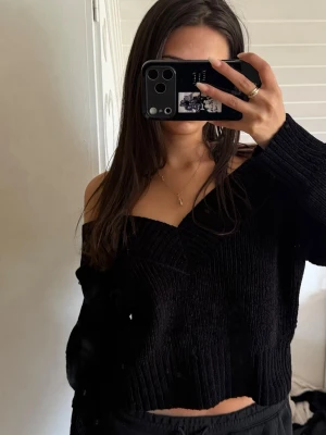 Svart off shoulder stickad tröja Divided - Säljer en svart stickad tröja från Divided by H&M. Tröjan har off shoulder-design, ribbstickat material och en croppad passform. 