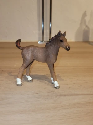 Brun hästfigur från Schleich - Säljer en brun hästfigur från Schleich med vita detaljer på benen och mörk man. Perfekt som dekoration eller leksak för dig som gillar djur och samlarfigurer. Realistisk design och smidigt format som passar på hyllan eller skrivbordet.