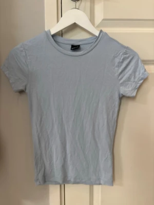 Tight T-shirt  - Säljer denna T-shirten från Gina tricot. Den är i strl Xs och använd fåtal gånger så inga defekter. Den är i ett väldigt skönt material. Skriv om ni har frågor!😊
