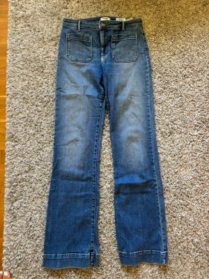 Flare jeans fickor fram - Så snygga vintage Wrangler jeans med hög midja och flare passform i blå wash. Stretchmaterial. Långa, 84 cm innerben och 39cm midjemått. Fickorna fram är öppna. INGA DEFEKTER