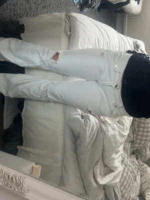 Vita jeans med slitningar - Säljer ett par vita jeans med utsvängda ben och coola slitningar vid knä och lår. Jag köpte dessa på plick för ett tag sedan men de visade sig vara för stora och därför säljer jag de igen💗(detta är också bilder från gamla ägaren så skriv privat om ni vill ha egna bilder!😇) 