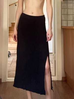 Snygg svart långkjol med slit - En svart långkjol med låg midja och en snygg slits på sidan. Kjolen har en enkel och stilren design som passar till många olika looks!😍Den har även en dragkedja på sidan. Materialet känns lätt och flowy, nästan som linne, perfekt för varmare dagar. Så snygg och enkel att bara sätta på sig, passar till allt!💞Mått: 34cm (midja), 81cm (längd). Passar 34 OM DU VILL HA DEN LÅGMIDJAD, 36 OM DU VILL HA DEN NORMAL MIDJA!! Hör av er vid frågor, pris diskuterbart❤️