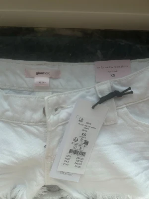 Vita denimshorts med fransar Gina Tricot - Säljer ett par vita denimshorts från Gina Tricot, modell '14+ for real low denim shorts'. De har låg midja, råa fransade benslut och klassisk femficksdesign. Perfekta för sommaren och riktigt snygga till crop tops eller linnen.
