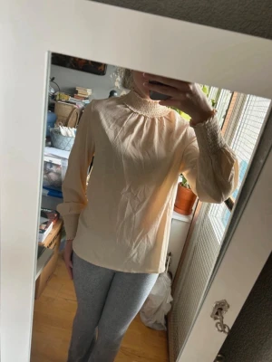 Beige blus med hög krage - Säljer en fin beige blus från Ginatricot i storlek 36.