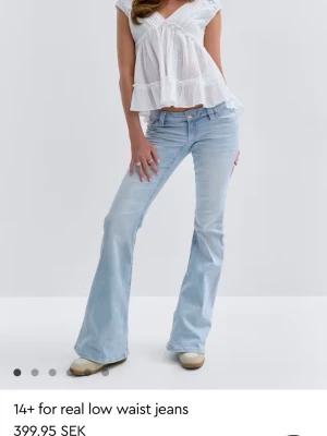 Ljusblå low waist bootcut jeans - Säljer ett par ljusblå low waist jeans med bootcut-modell från 14+ for real. Jeansen har klassiska fem fickor, dragkedja och knapp framtill samt snygga sömdetaljer bak. Perfekta för dig som gillar retrovibbar och relaxed stil.