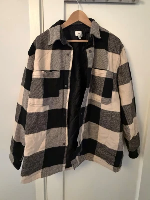 Svartvit rutig overshirt - Overshirt i svart och beige rutigt mönster från hm. Sällan använd endast ett antal gånger.