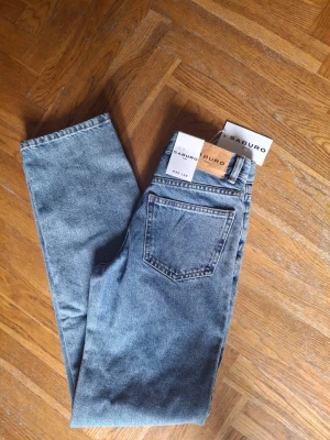 Midstone tvättade jeans från Saburo - Säljer ett par snygga midstone tvättade jeans från Saburo i modellen Women's Regular. Klassisk femficksdesign, rak passform och tillverkade i slitstark denim. Perfekta för dig som gillar en tidlös och avslappnad look.