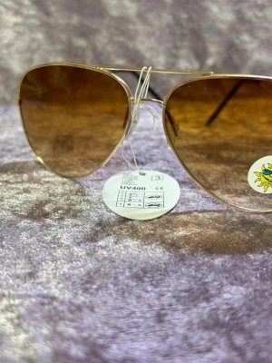 Guldiga aviator solglasögon - Snygga aviator solglasögon med guldfärgad metallbåge och bruna tonade glas. Klassisk pilotmodell som ger en cool vibe till din outfit. Lätta och bekväma att bära, perfekta för soliga dagar. 135kr/st  helt ny 
