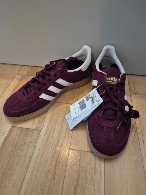 Adidas spezial - Helt nya Adidas originals handball spezial med prislapp kvar, storlek 39 1/3 i färgen maroon/crewht/goldmt (vinröd färg).