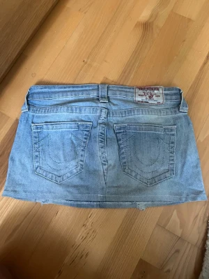 Lågmidjad jeanskjol från True Religion - Säljer en skitsnygg vintage jeanskjol från True Religion med klassiska bakfickor. Använd ett fåtal gånger i jättefint skick🩷storleken motsvarar S🥰