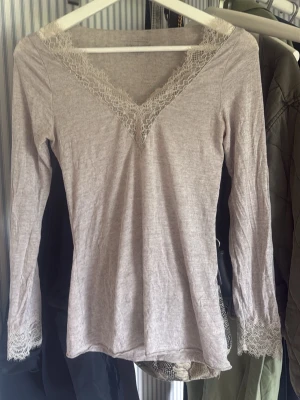 Beige långärmad intimissmi topp med spets - Helt oanvänd beige intimissmi tröja med V-ringning, spetsdetaljer och en lite lila nyans🙌🏻 