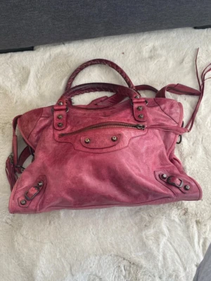 Rosa Balenciaga City bag väska - Så sjukt fin vintage rosa balenciaga citybag väska i den större modellen! Får plats med dator och skolböcker mm. Bra skick, spegeln är kvar och skickas med😊 väskan är köpt på vestarie! Kan även mötas upp i Göteborg om så önskas.