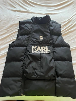 KARL KARLLAGERFELD VÄST - Använd ca 1 vecka. Inga skador. Scam funkar. Går in till Karl KARLLAGERFELD hemsidan.
