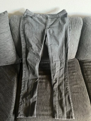 Grå raka jeans - Säljer ett par grå jeans med rak passform och klassisk femficksdesign. Jeansen har normal midja och är tillverkade i ett mjukt denimtyg som ger en avslappnad look. Perfekta till en enkel t-shirt eller hoodie.