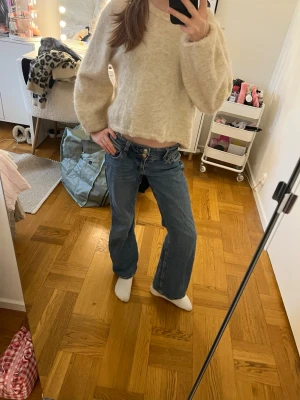Blåa low waist jeans - Säljer ett par blåa low waist jeans. Jeansen har en avslappnad passform och är perfekta för en trendig och avslappnad look. Stängs med dragkedja och knapp framtill. 