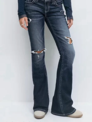 Blå bootcut jeans med slitningar - Säljer ett par blå bootcut jeans med slitningar och snyggt broderad bakficka. Jeansen har ljusa tvättade partier och detaljerade sömmar. Är från young gina och är låååg midjade.
