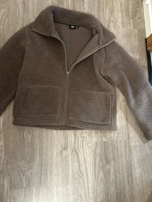 Brun teddyjacka med dragkedja - Mysig brun teddyjacka från lager 157 med hög krage och hel dragkedja framtill. Jackan har två stora fickor framtill och är tillverkad i fluffigt teddy-material som håller dig varm. Perfekt för våren och ger en avslappnad look. (PRISET GÅR ATT DISKUTERA KAN SÄNKA HUR MYCKET SOM HELST)!!!